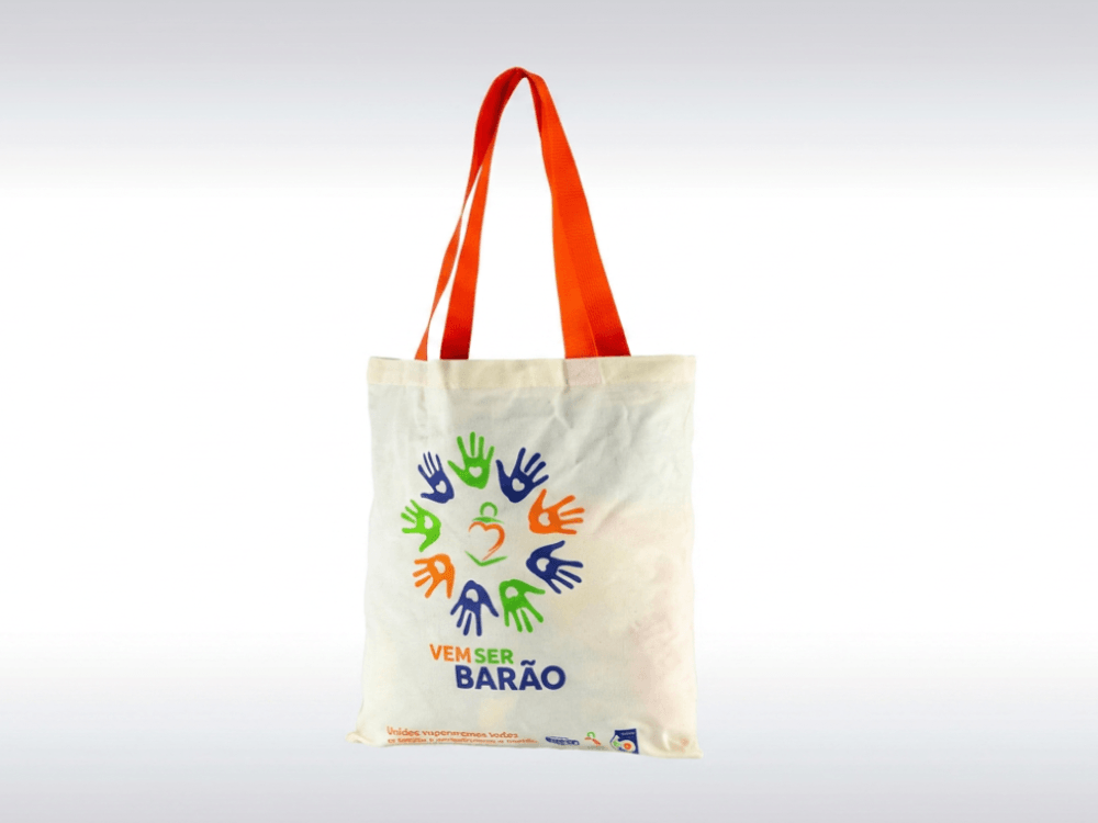 Ecobag de tecido com alças laranja e estampa colorida na parte frontal, representando um tamanho versátil para diferentes usos.